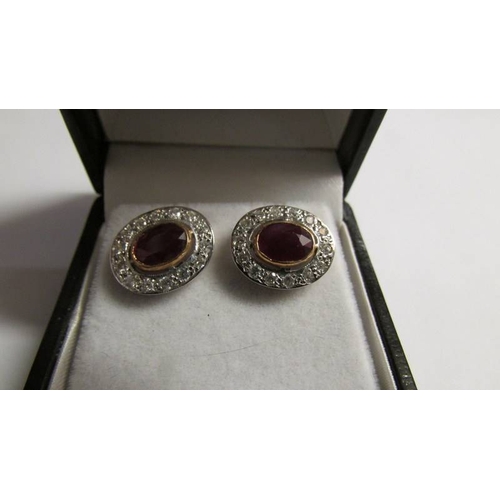 2005 - A pair of oval ruby and diamond gold earrings.