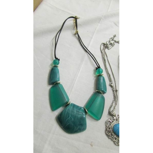 1039 - A white metal leaf necklace set blue stones and 3 turquoise coloured necklaces.