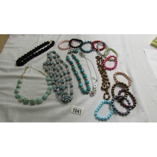 1041 - A black rope necklace, 5 other necklace and a quantity of coloured bracelets.