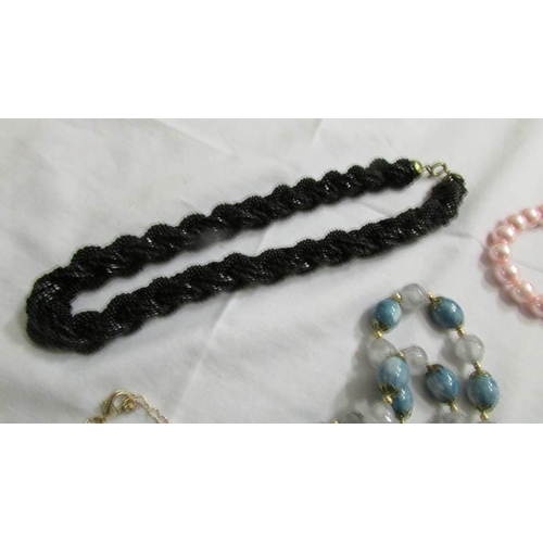 1041 - A black rope necklace, 5 other necklace and a quantity of coloured bracelets.