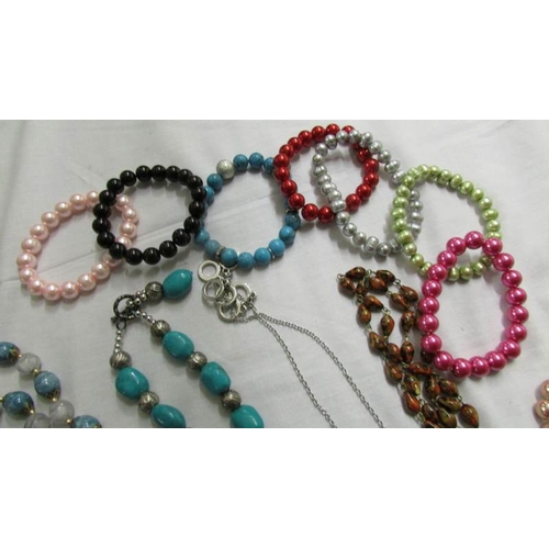 1041 - A black rope necklace, 5 other necklace and a quantity of coloured bracelets.