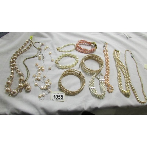 1055 - A quantity of 'pearl' necklaces and bracelets.