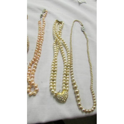 1055 - A quantity of 'pearl' necklaces and bracelets.