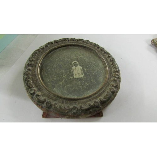 2072 - A small antique silver photo frame, a silver babies rattle a/f and an silver ring.