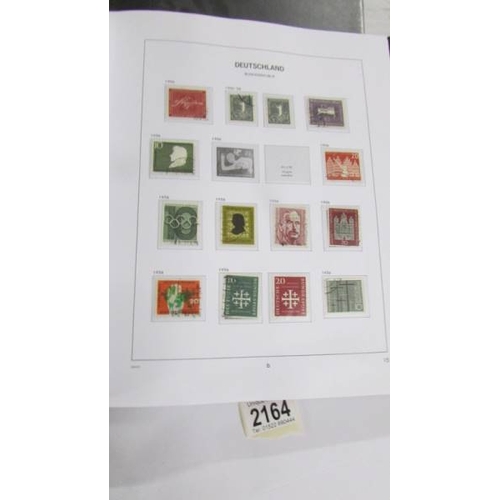 2164 - An album of German postage stamps and three other albums of stamps including Hong Kong, Tuvalu, USA,... 