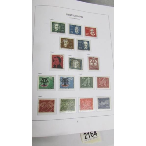 2164 - An album of German postage stamps and three other albums of stamps including Hong Kong, Tuvalu, USA,... 