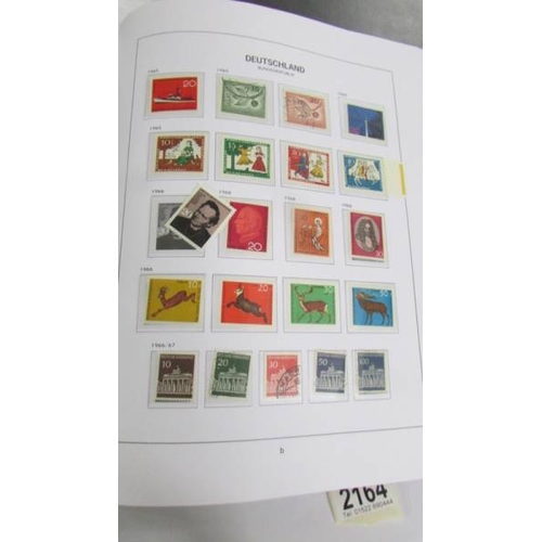 2164 - An album of German postage stamps and three other albums of stamps including Hong Kong, Tuvalu, USA,... 