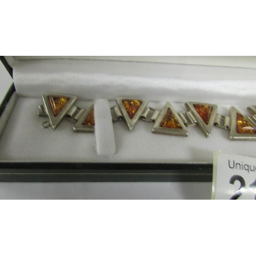 2108 - An amber bracelet set in silver designed a triangles in textured silver.