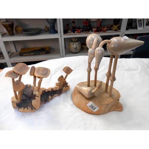 265 - A carved wooden mushroom and bird family displays