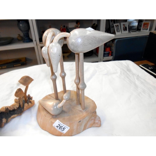 265 - A carved wooden mushroom and bird family displays