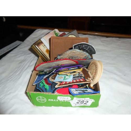 282 - A box of sew on patches including girl guides, plus pin badges, small books (Scottish songs, The Spa... 