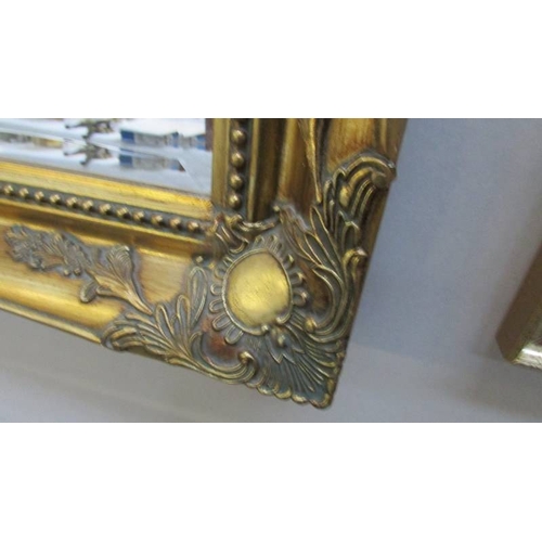 1144 - A large gilt framed bevel edged mirror.