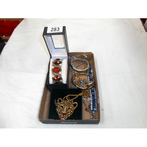 283 - A tray of costume jewellery, bangles, bracelets and leopard pendant