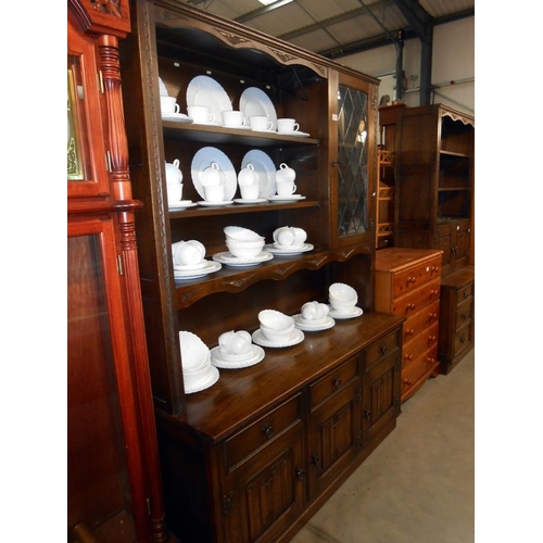 371 - A dark oak cottage dresser with leaded glass doors and drape panels