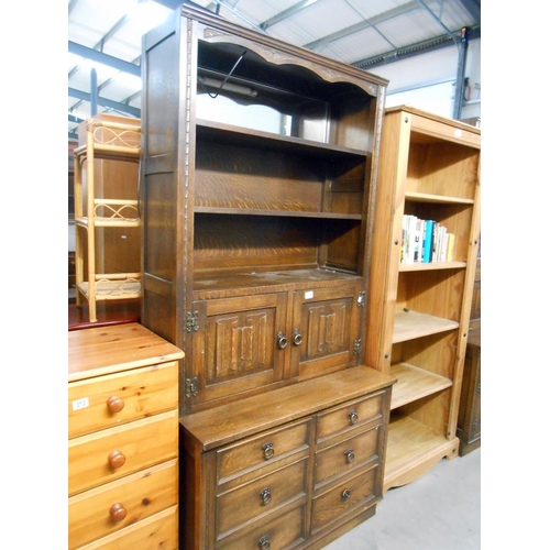 374 - A dark oak drawer based dresser with carved drape panel doors, Height 194cm, width 94.5cm approx.