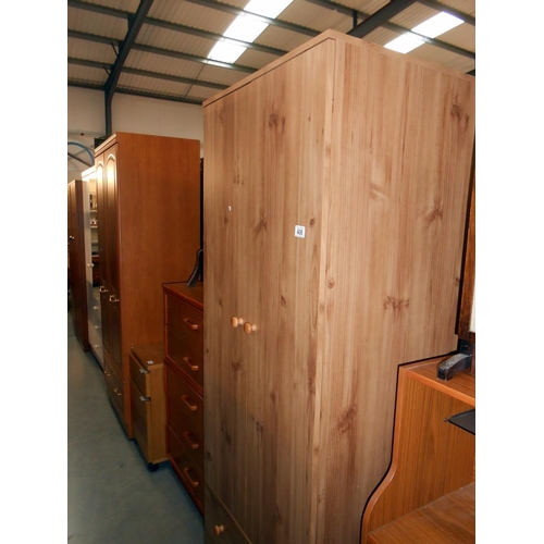 406 - A modern 2 door 2 drawer pine effect wardrobe, height 181cm, width 67cm, approx.