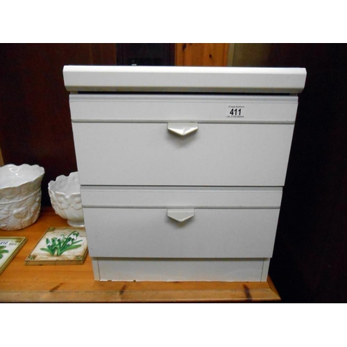 411 - A white bedside chest of drawers with glass top, height 52cm, width 45cm approx.