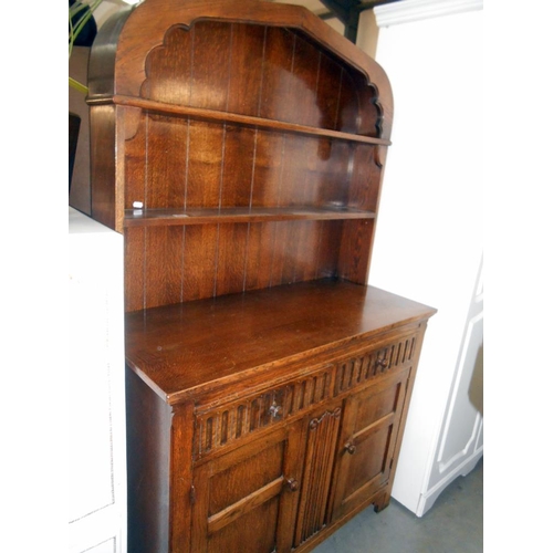 485 - A solid oak arch top cottage dresser with drape carved front, height 182cm, width 112cm approx.