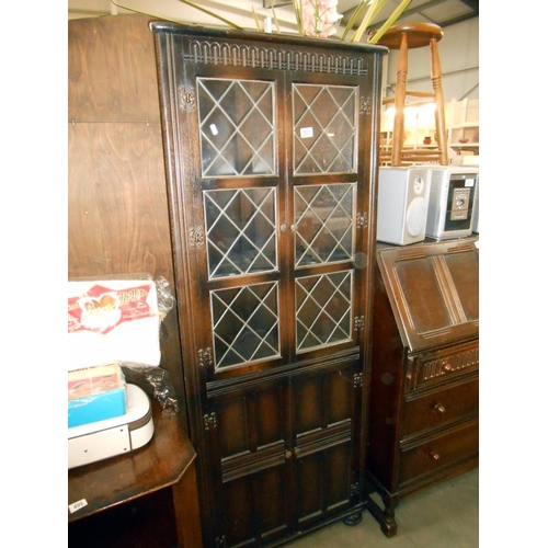 500 - A dark oak cottage corner cupboard with leaded glass doors, height 169cm, width 66cm, depth 31cm app... 