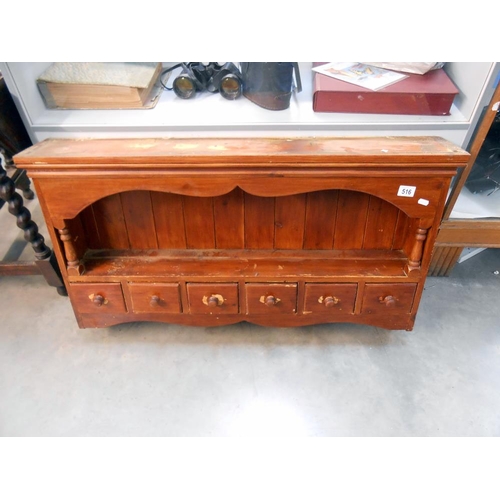 516 - A stained pine kitchen wall shelf unit with drawers, height 57cm at tallest point, width 102cm