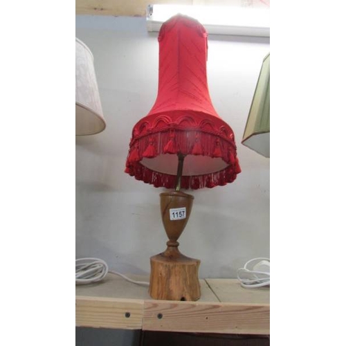 1157 - Three craftsman turned wooden table lamps with shades, approximate heights 57 - 65 cm.