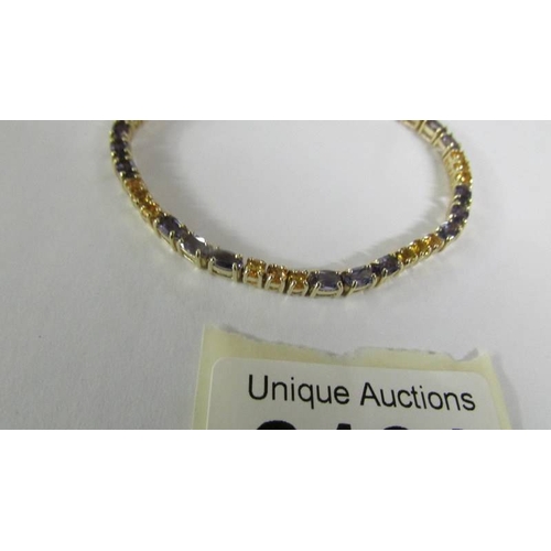 2121 - A tanzanite and citrine tennis bracelet with 21 tanzanites and 21 citrines in a 9ct gold setting, to... 