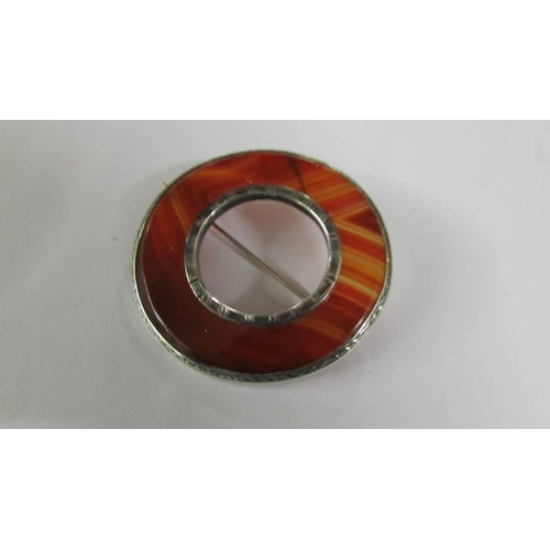 2130 - A banded agate early 20th century Scottish brooch together with a further stone set brooch, a green ... 