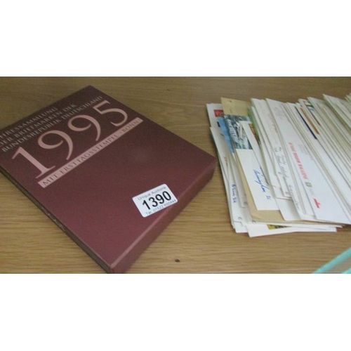 1390 - A quantity of first day covers and an album of stamps.