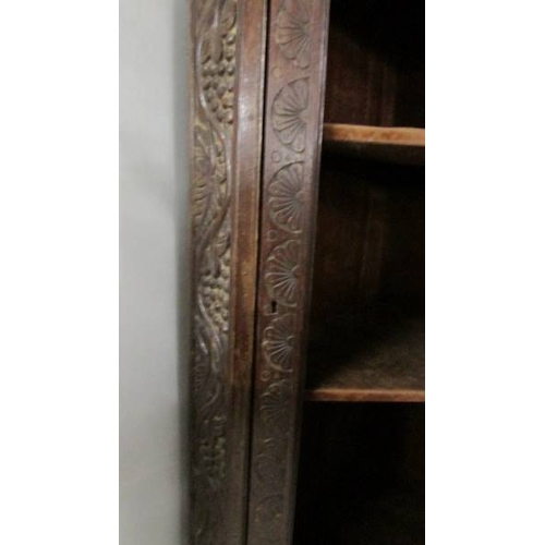 2211 - An antique carved oak corner cabinet (missing glass from door).