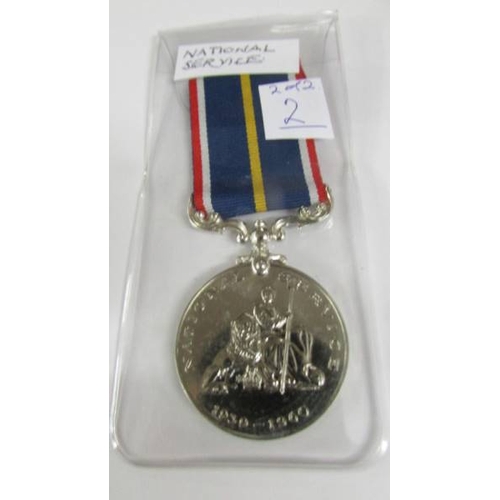 2240 - A boxed 'Battle of Britain' medal bar 'Royal Air Force' with a National Service Medal.