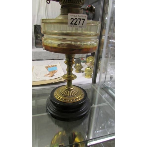 2277 - A Victorian oil lamp with brass column, glass font and complete with burner, shade and chimney.