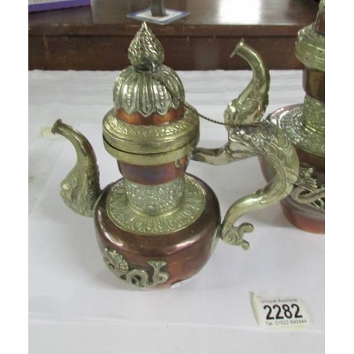 2282 - Two copper and white metal Tibetan teapots, 20th century, 28 and 23 cm tall.