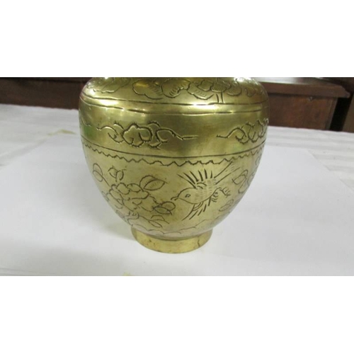 2293 - An oriental brass dragon vase depicting birds and flowers, 24 cm high.