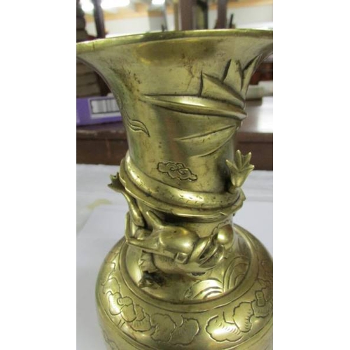 2293 - An oriental brass dragon vase depicting birds and flowers, 24 cm high.