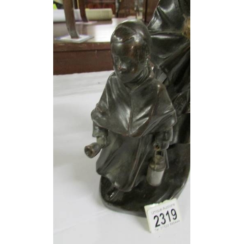 2319 - A bronzed model of a monk with child.