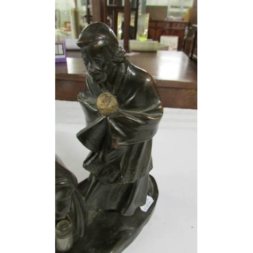 2319 - A bronzed model of a monk with child.