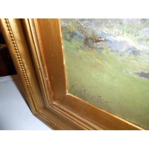 2184 - A gilt framed oil on board rural scene, signed but indistinct.