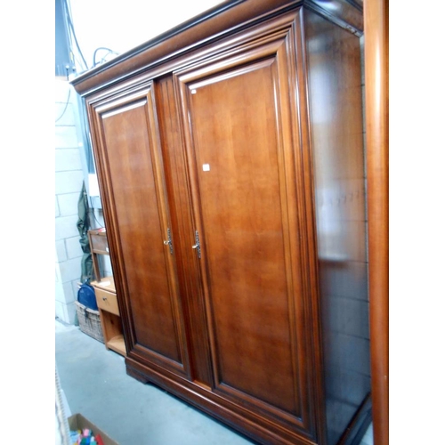 73 - A large darkwood stained 2 door wardrobe with adjustable shelves, height 212cm, width 170cm, depth 6... 