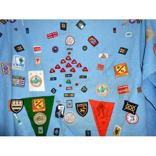 108 - An old scouts blanket with large quantity of scouting badges sewn on