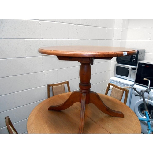 147 - A solid dark pine round kitchen table on centre column with 4 legs