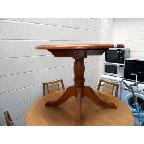 147 - A solid dark pine round kitchen table on centre column with 4 legs