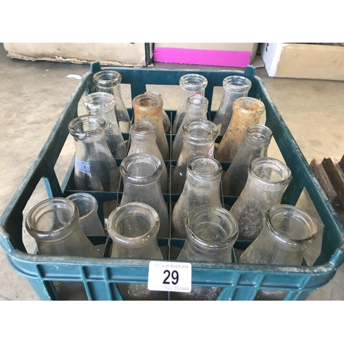 29 - A crate with 20 various clear glass milk bottles