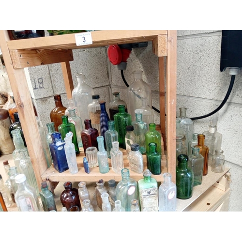 3 - 3 shelves of decorative bottles, some marked poison