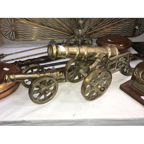 1034 - A selection of brass & copper including Peacock/fan fire screen, toasting forks & large heavy cannon... 