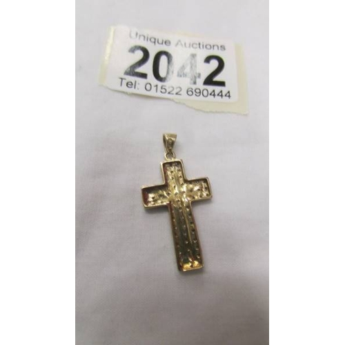 2042 - A gold and diamond cross pendant.