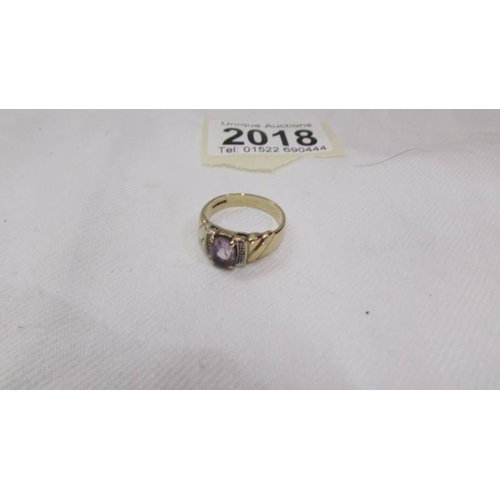 2018 - An oval amethyst ring set with diamond shoulders, 375 9ct gold, size O half.