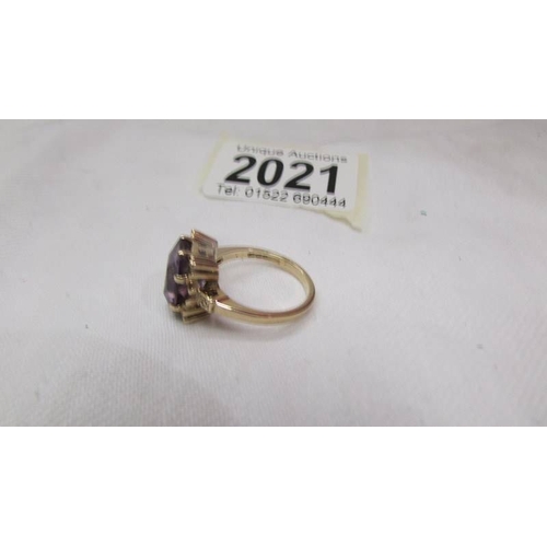 2021 - An amethyst set oblong ring with fancy textures gold shoulders and mount, set in 9ct gold, size O.