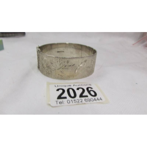 2026 - A good quality heavy silver bangle textured with trailing all round leaves, dated Birmingham 1974.