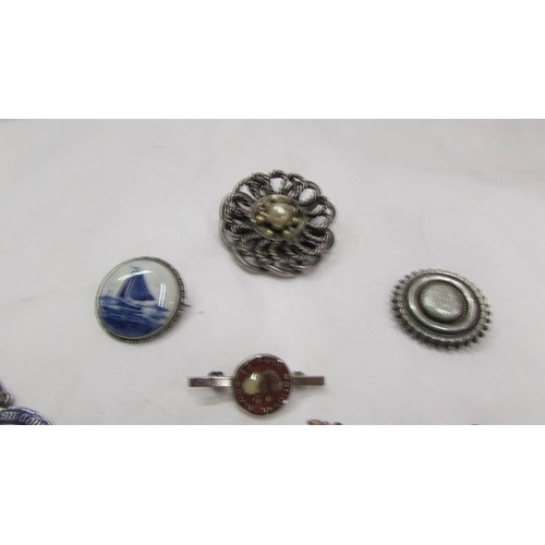 2037 - A silver 'Delft' brooch, a silver blood doner badge, a silver medallion, three silver fobs, a silver... 