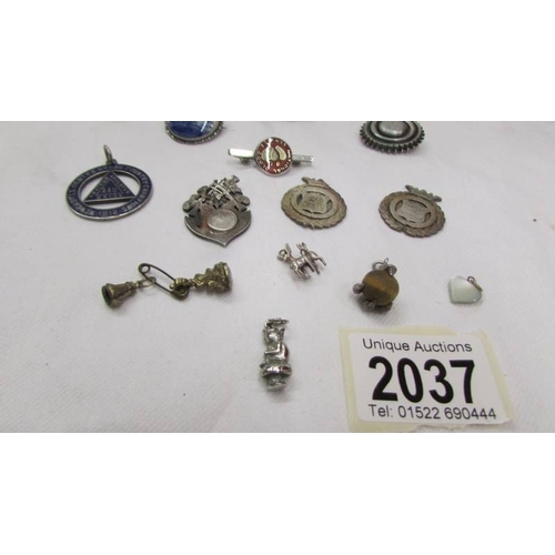 2037 - A silver 'Delft' brooch, a silver blood doner badge, a silver medallion, three silver fobs, a silver... 